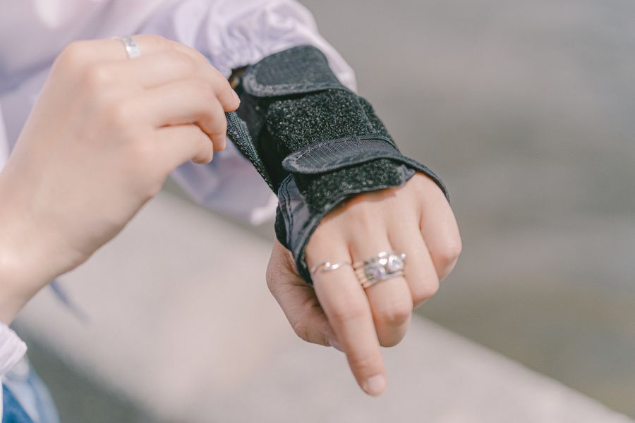 Close-up of a hand adjusting a wrist brace used in de Quervain's treatment
