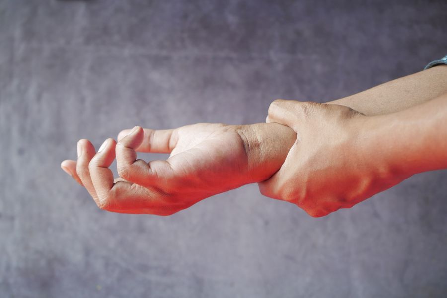 Close-up of hands grasping each other, representing the pain and discomfort of a nerve injury