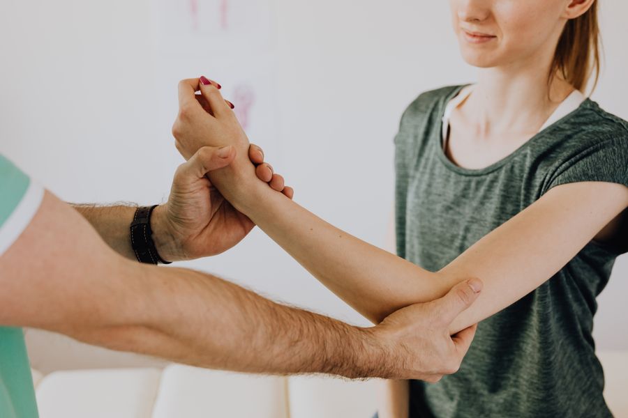 Medical professional examining a patient's arm and wrist joint for nerve function assessment